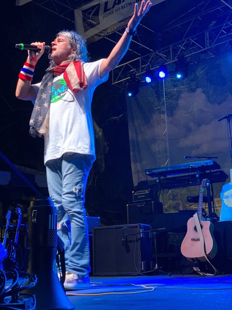 Spank The Monkey vocalist performing under blue stage lights